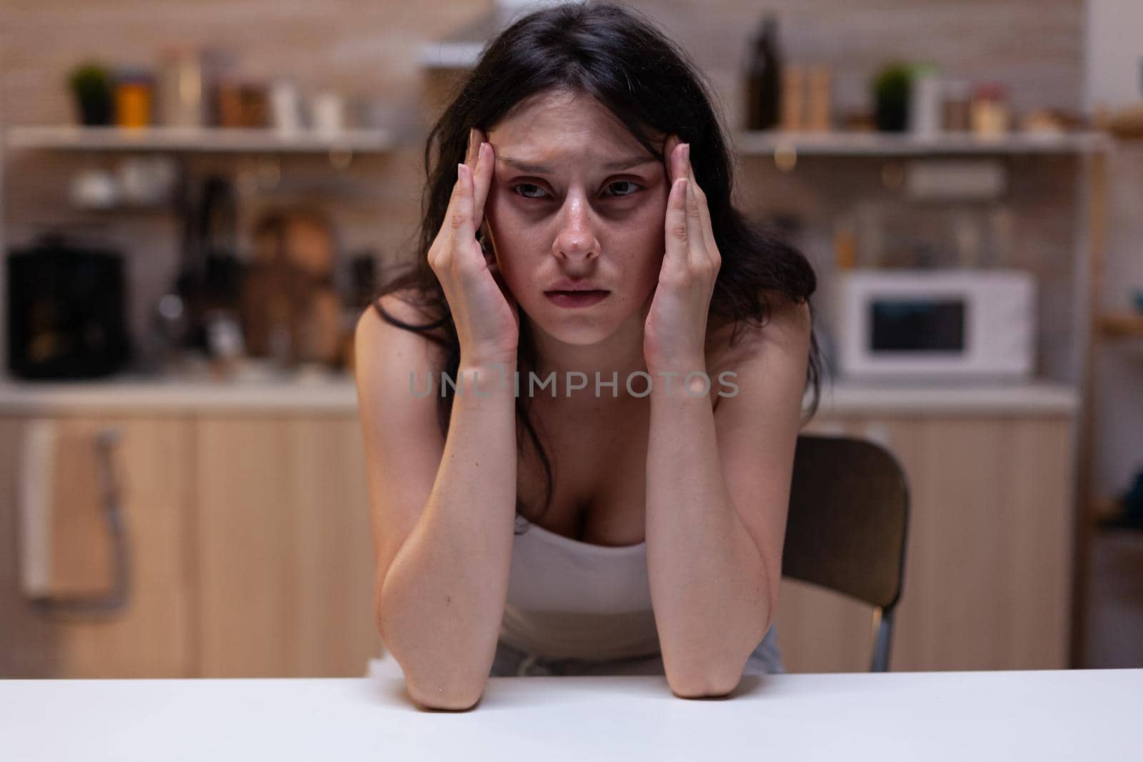 Portrait of upset woman with serious headache pain holding hand on temples because of stress. Person feeling depressed at home having migraine from fatigue and depression problems
