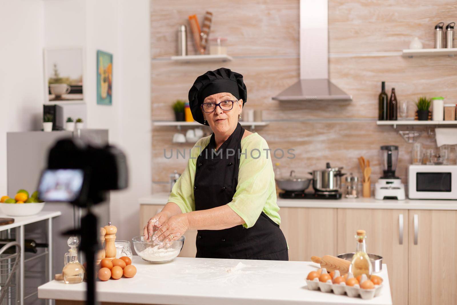 Old lady baker presenting food recipe by DCStudio