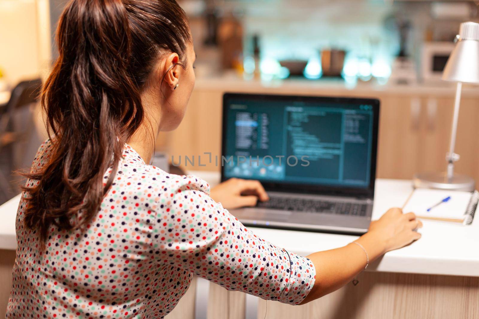 Hacker woman stealing people money using a malicious virus . Programmer writing a dangerous malware for cyber attacks using performance laptop during midnight.