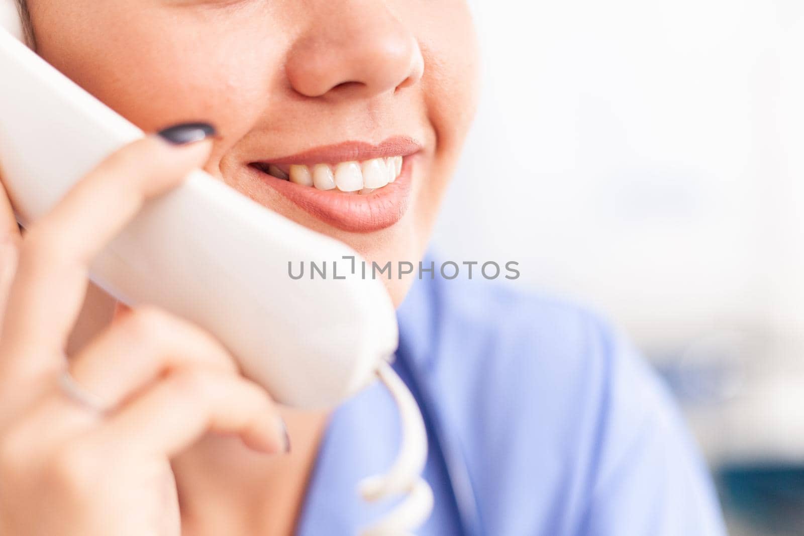 Woman nurse answering telephone by DCStudio