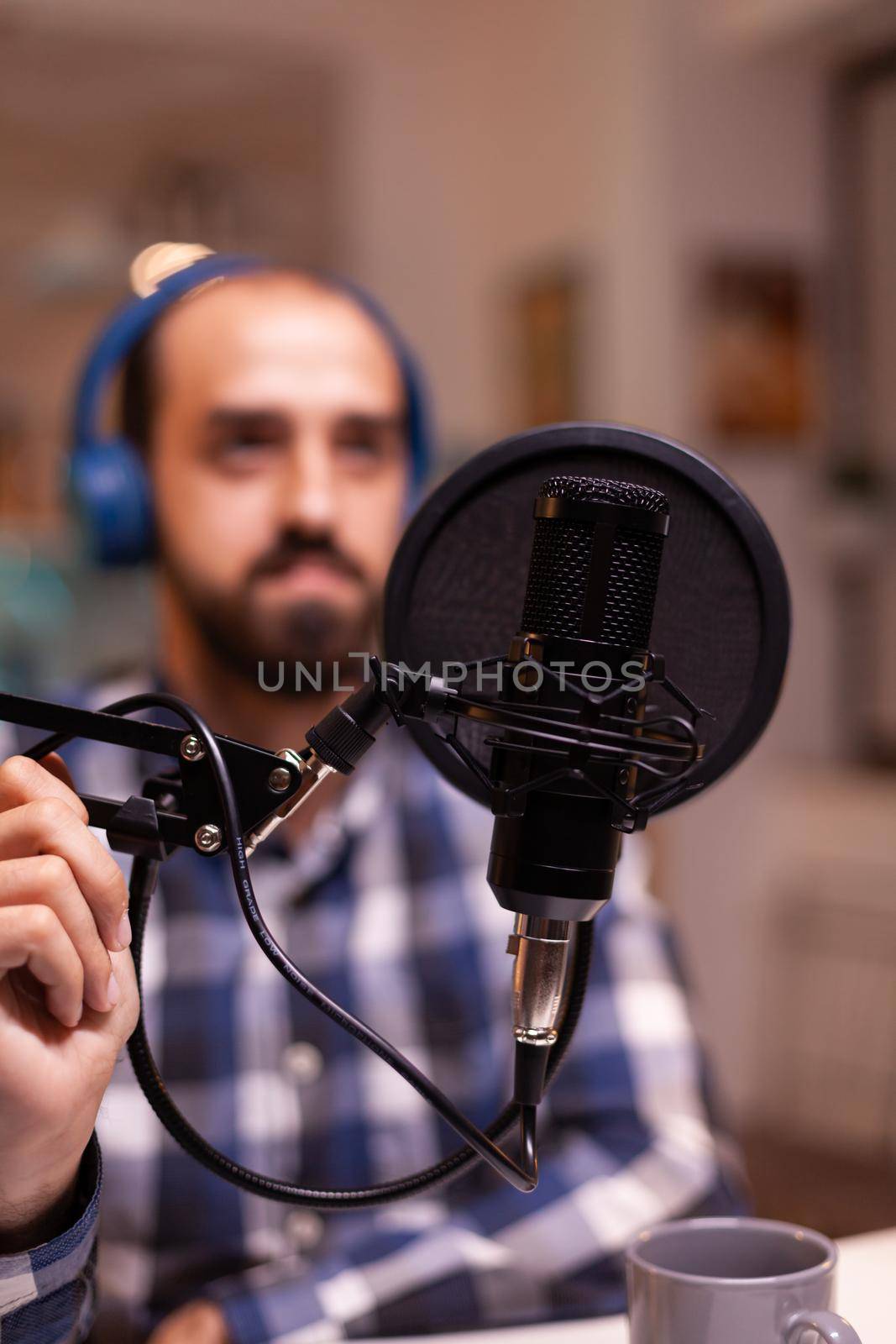 Close up of vlogger holding micophone while speaking during online interview. Online show On-air production internet broadcast host streaming live content, recording digital social media communication