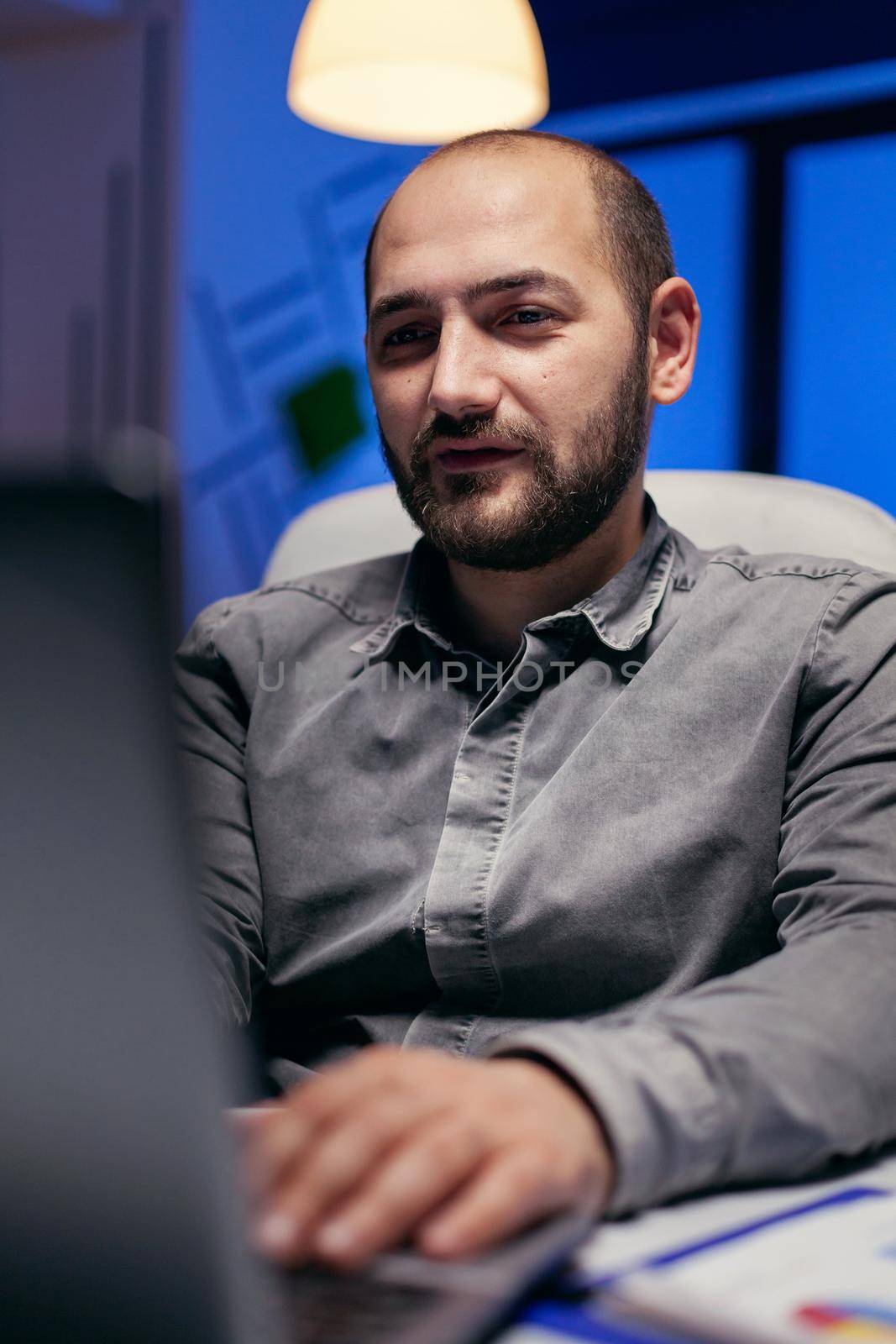 Close up of entrepreneur reading article on laptop doing overtime to finish a project Smart businessman sitting at his workplace in the course of late night hours doing his job.