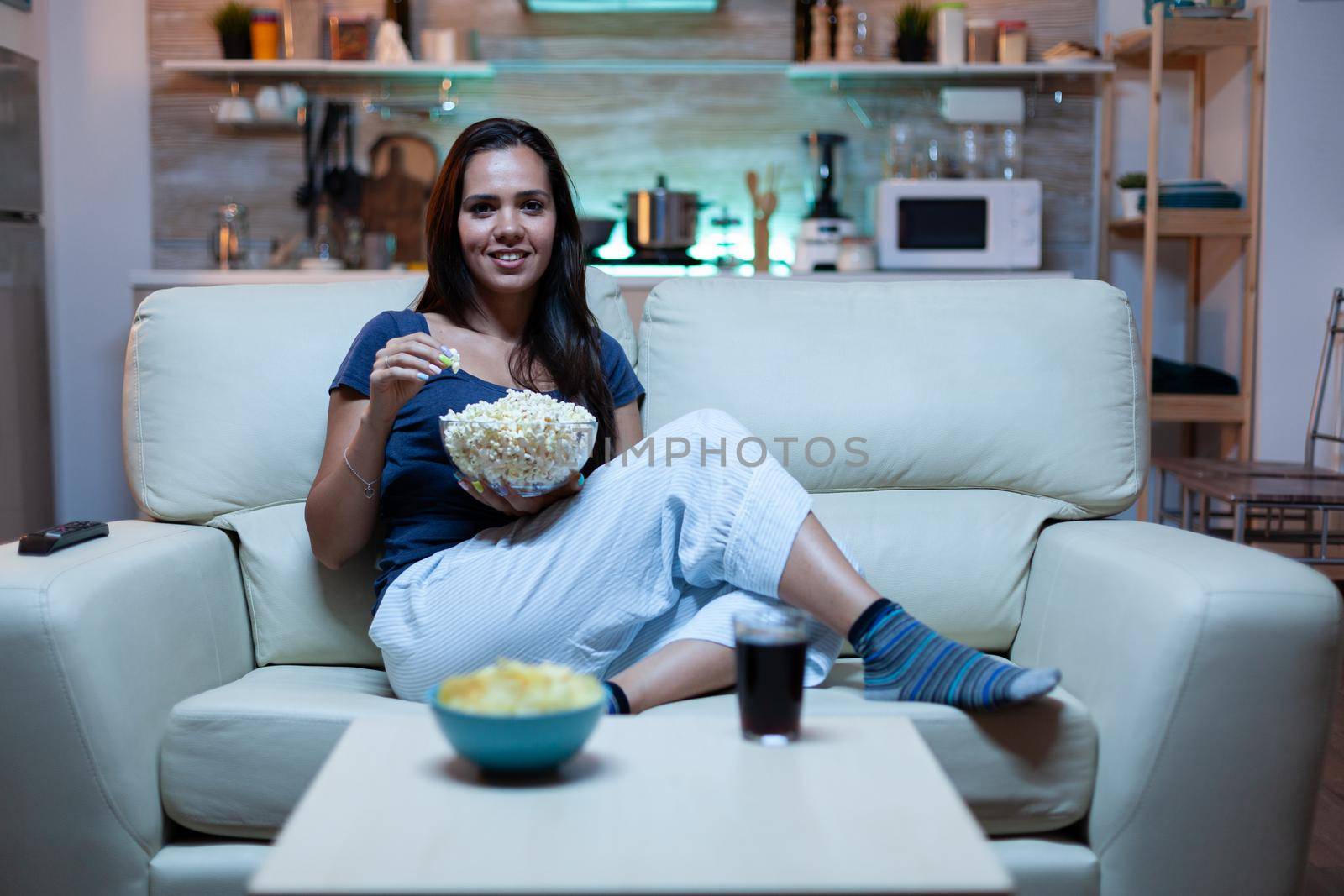 Lady resting with snaks watching a movie by DCStudio