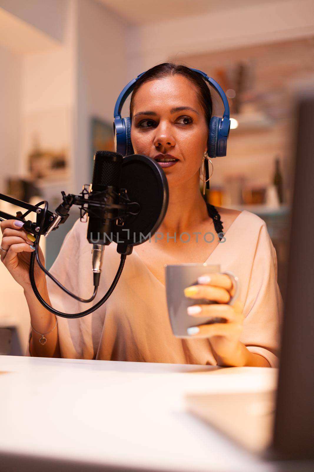 Talking on professional microphone during vlog recording in kitchen. On-air online production internet broadcast show host streaming live content, recording digital social media communication