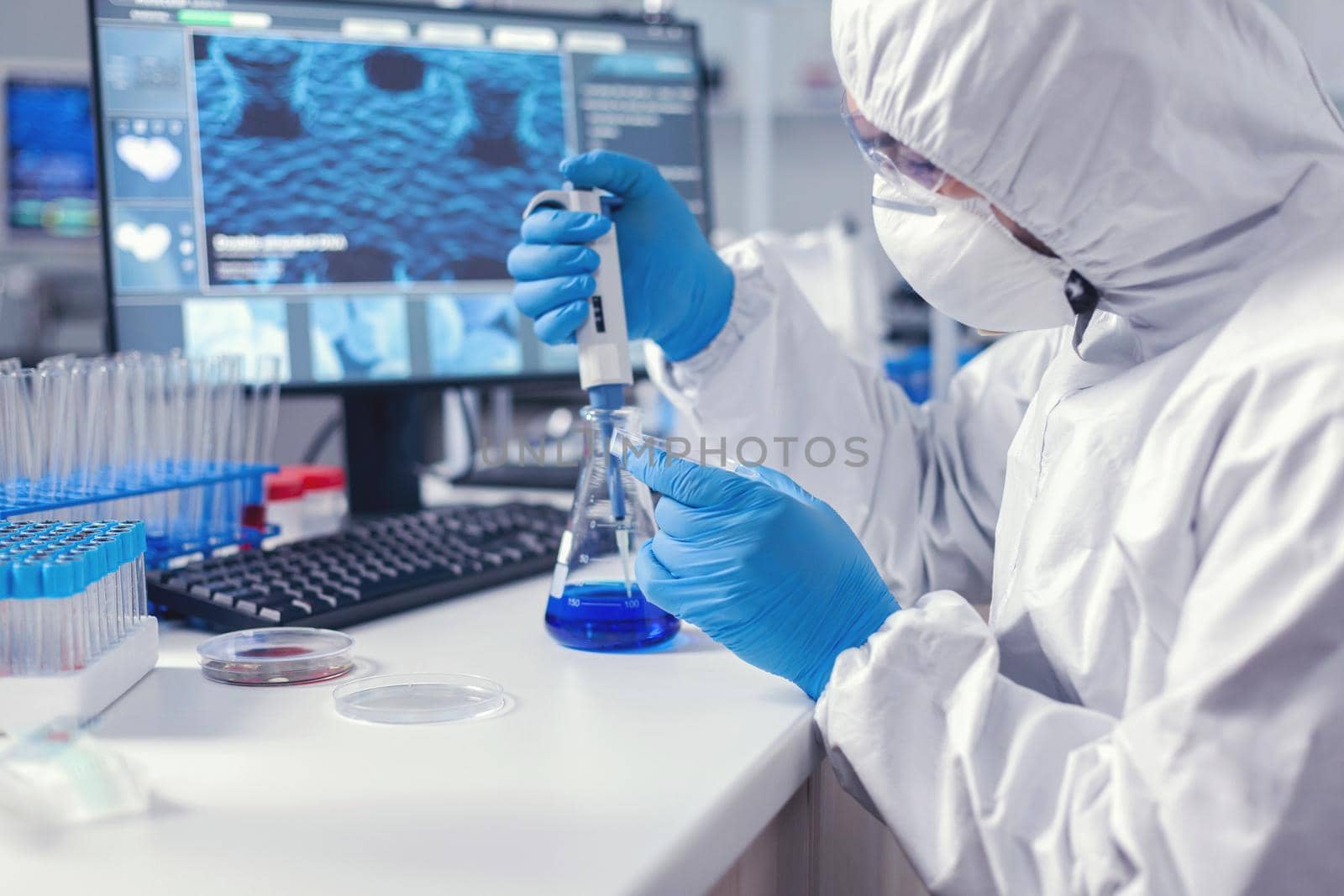 Man in microbiology lab holding petri dish by DCStudio