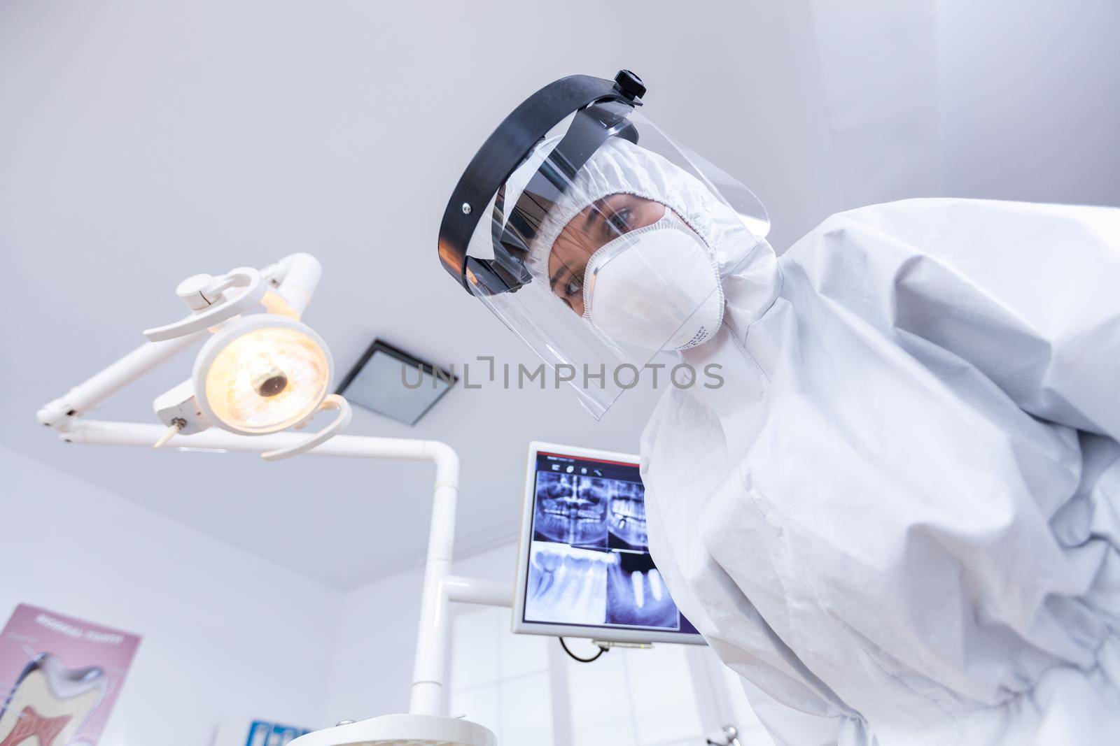 Dentist point of view wearing protection gear against covid outbreak during treatment in dental office. Stomatolog wearing safety gear against coronavirus during heatlhcare check of patient.