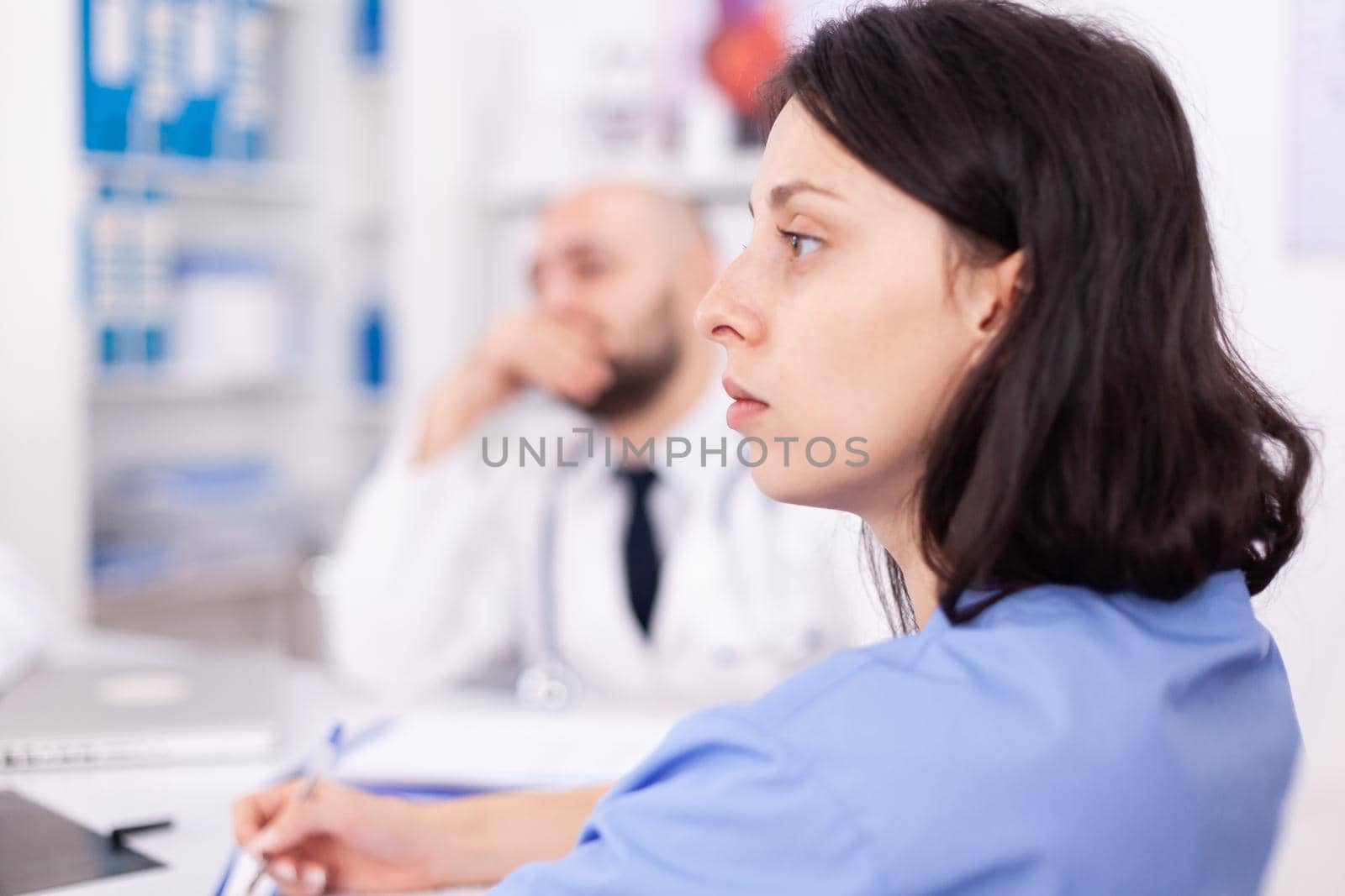 Nurse listening expert doctor during medical conference in hospital meeting room. Clinic expert therapist talking with colleagues about disease, medicine professional