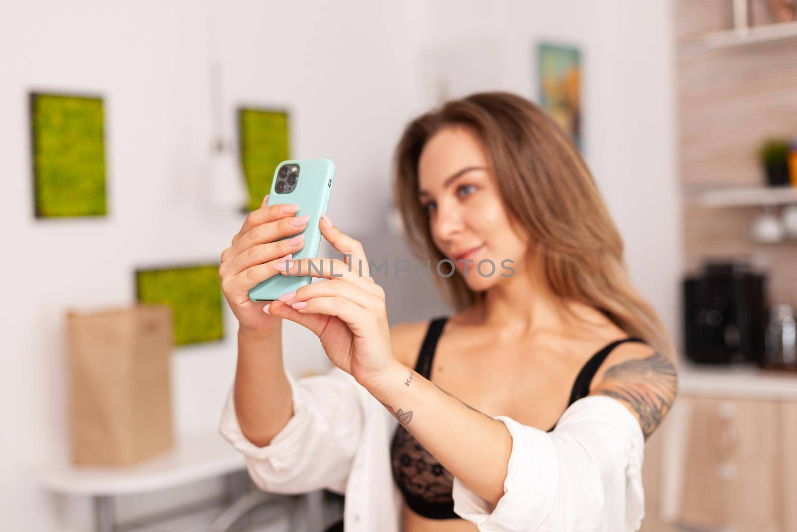 Portrait of beautiful woman looking at phone camera by DCStudio