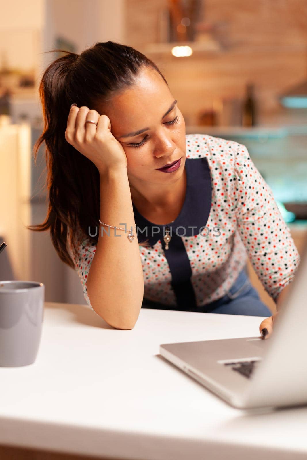 Woman keeping eyes closed because of exhaustion while working on a project for work late at night. Employee using modern technology at midnight doing overtime for job, business, busy, career, network.