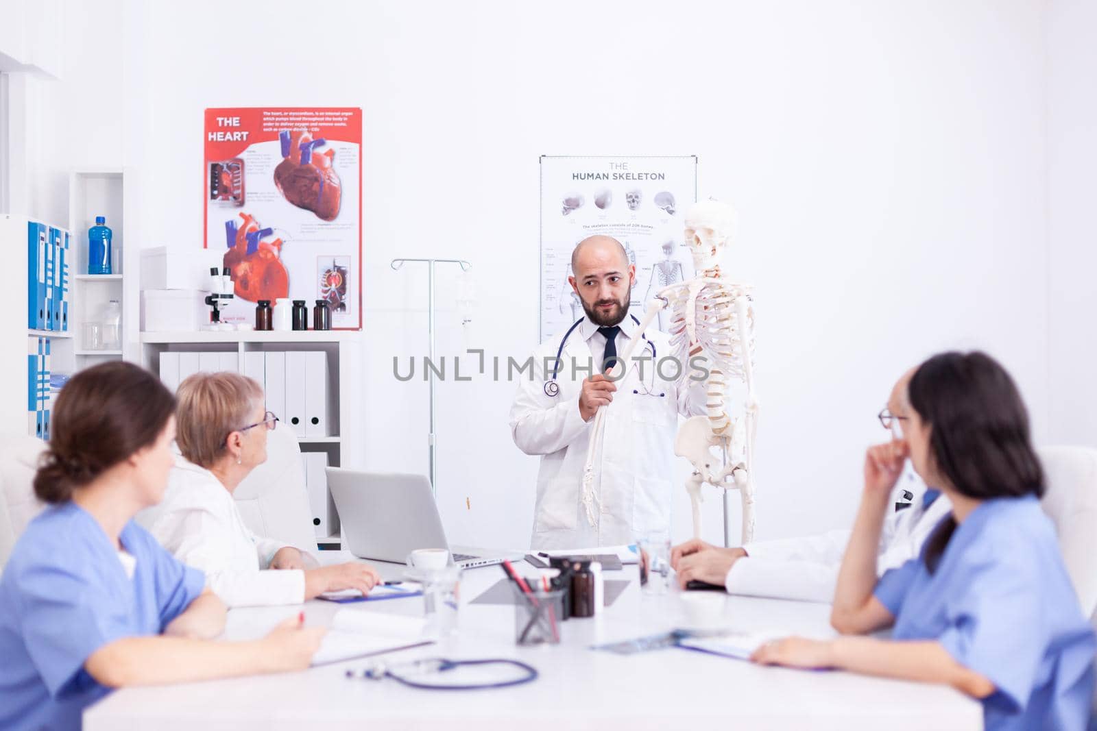 Expert radiologist demonstrating on skeleton by DCStudio