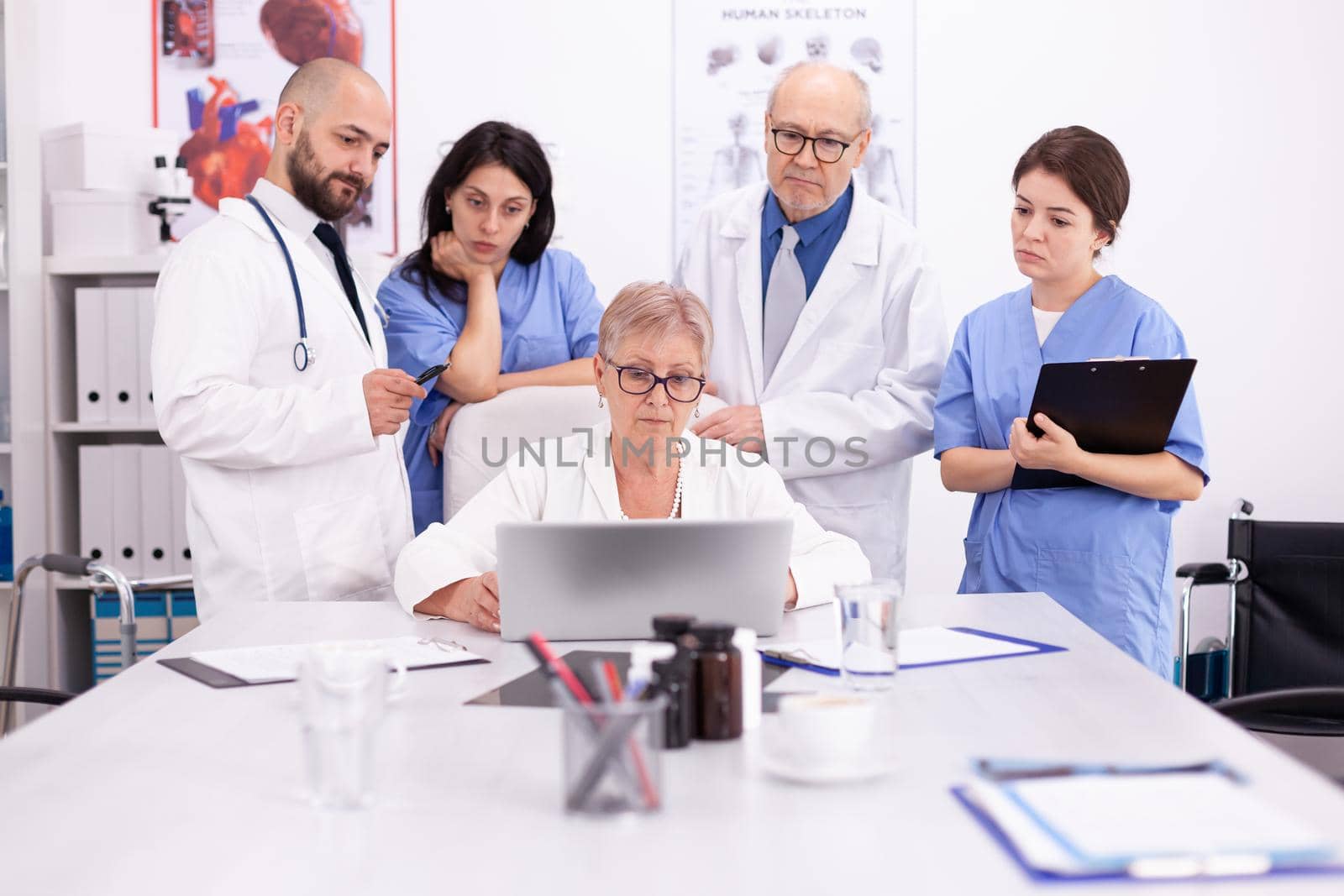 Team of doctors looking at laptop by DCStudio