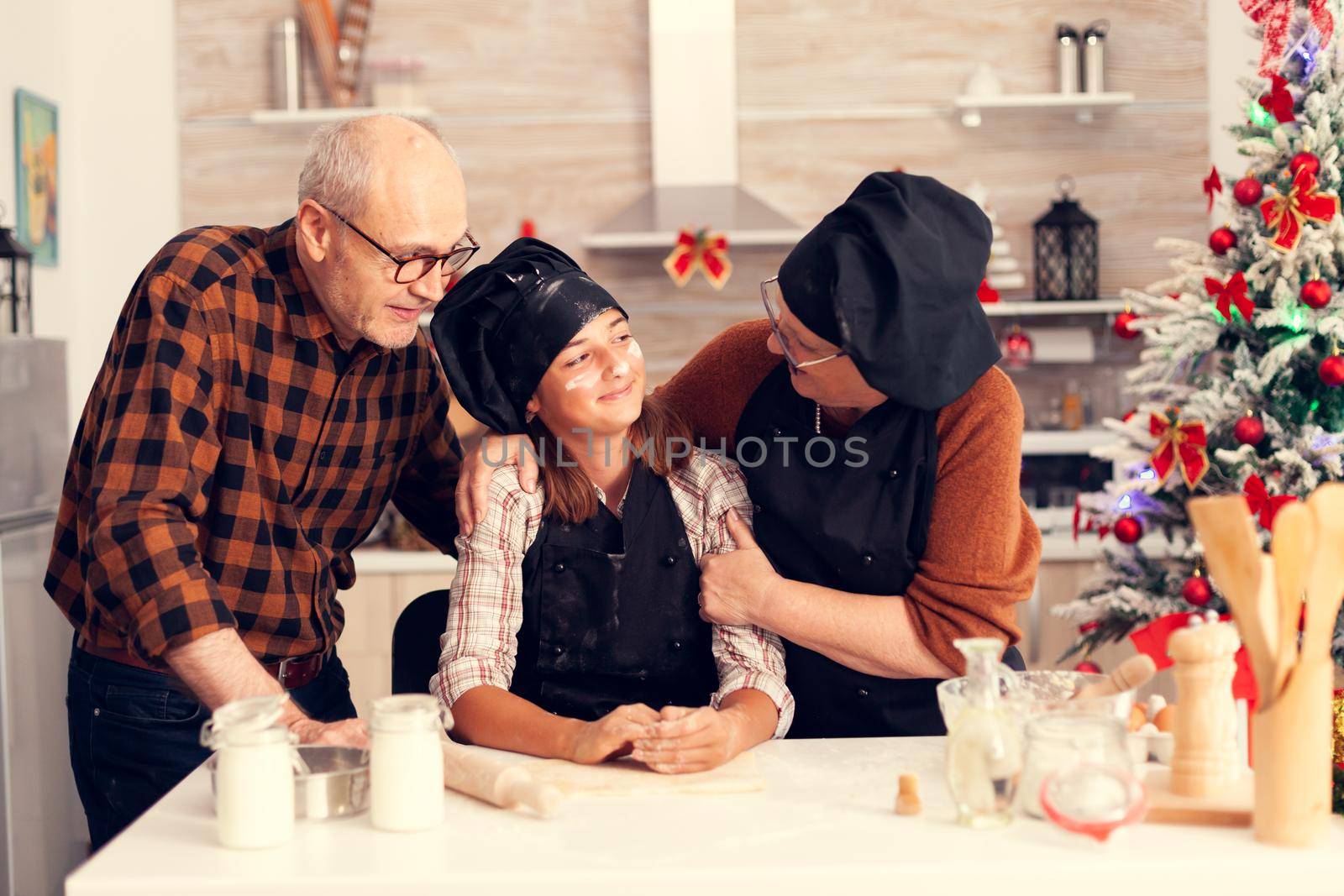 Happy grandparent and child on christmas day making dessert by DCStudio