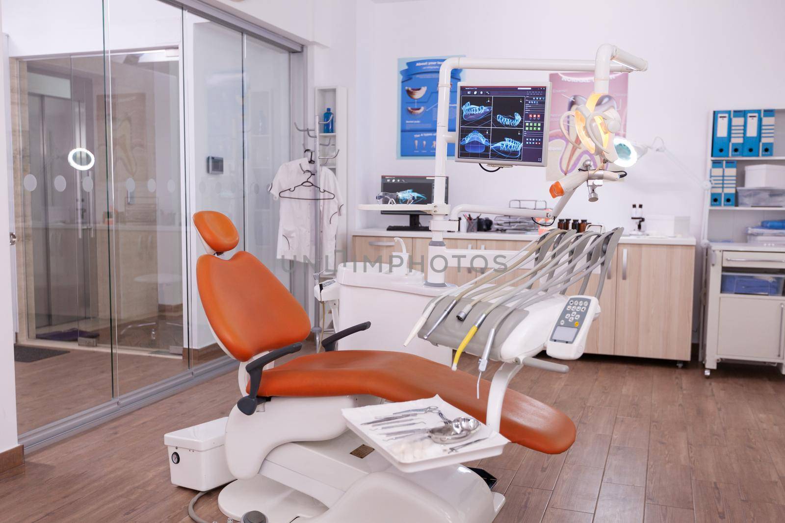 Empty dentistry orthodontist stomatology office with nobody in it. Light modern equipped stomatology workplace, teeth hygiene and care. Hospital dental health. Tooth xray image on monitor