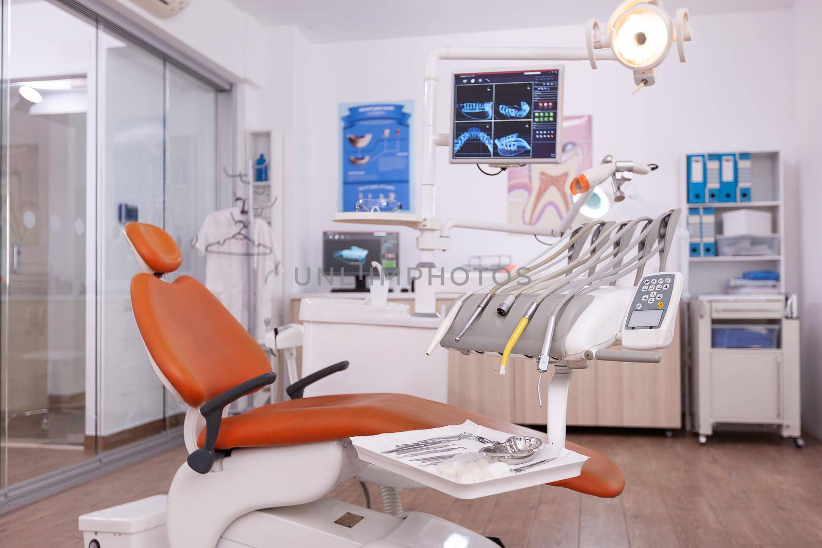 Interior of empty oral stomatology orthodontist office with dental teeth radiography on monitor. Professional dentistry hospital room with nobody in it prepared for tooth diagnosis treatment