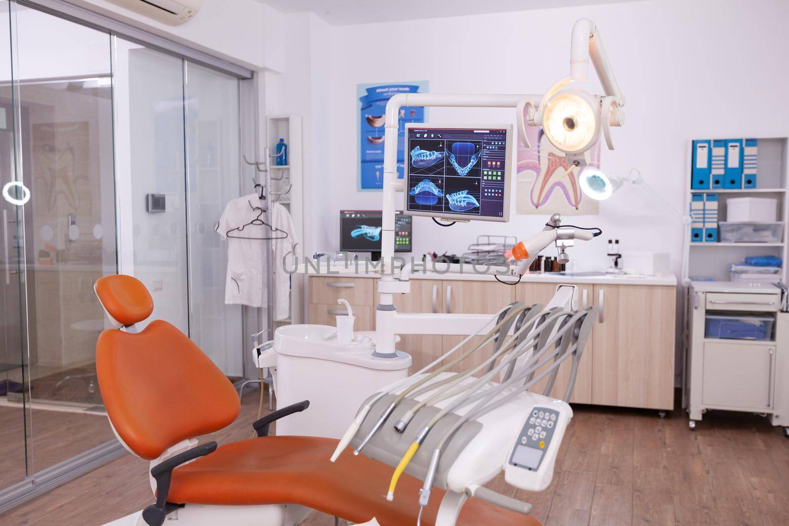 Empty medical clinic orthodontic hospital room with stomatology dental equipment, ready for dentistry surgery. Orthodontist chair with nobody on it, teeth diagnosis radiography images on display