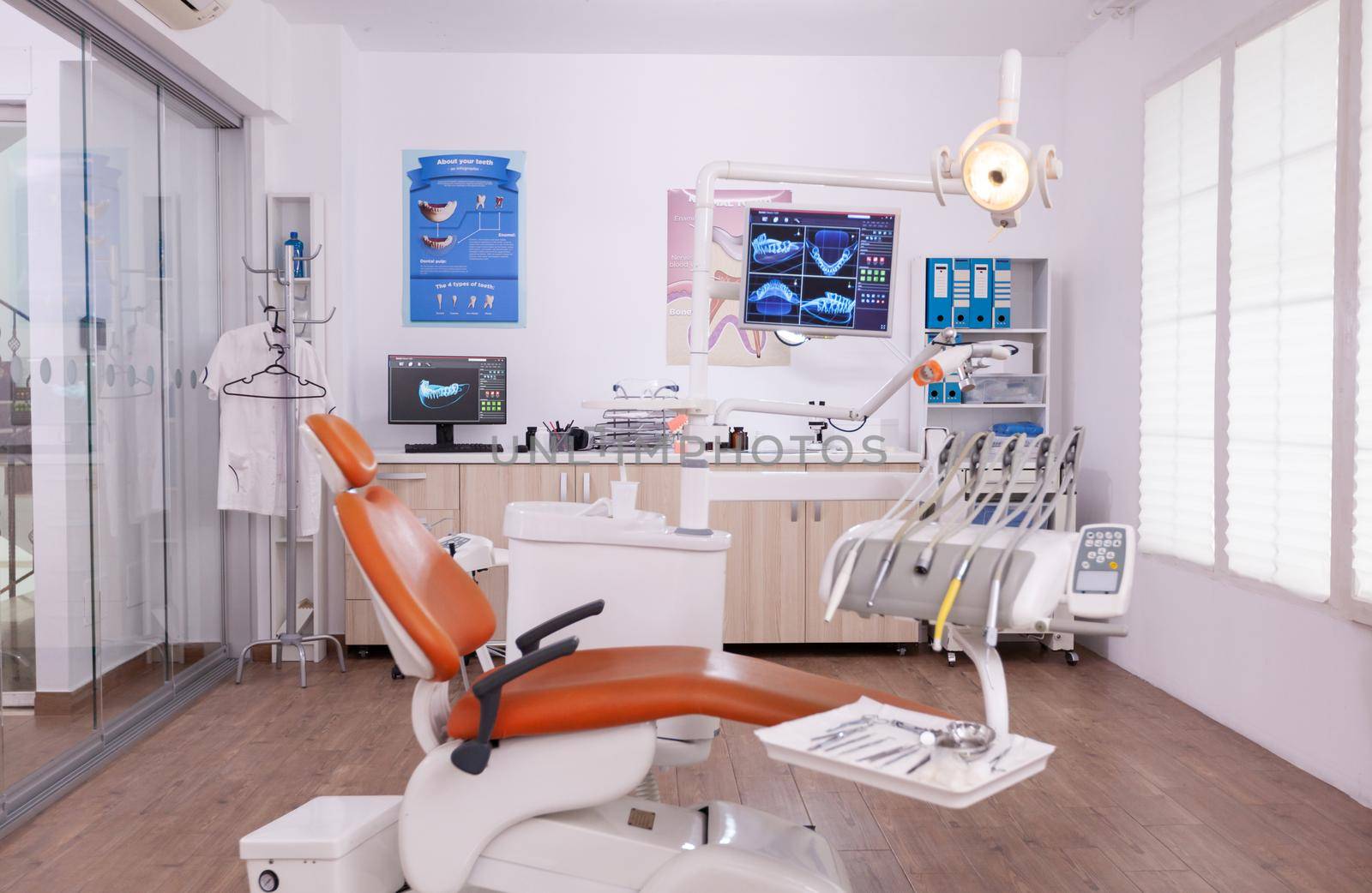 Interior of empty professional modern stomatology hospital office ready for dental tooth surgery. Orthodontic cabinet teeth drill instruments with orthodontist chiar prepared for teethcare treatment