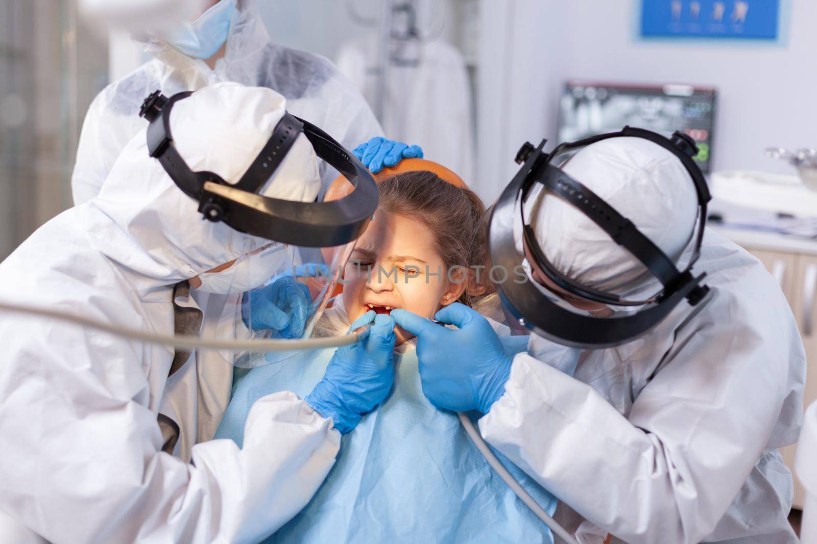 Woman dentist doctor treating little girl tooth by DCStudio