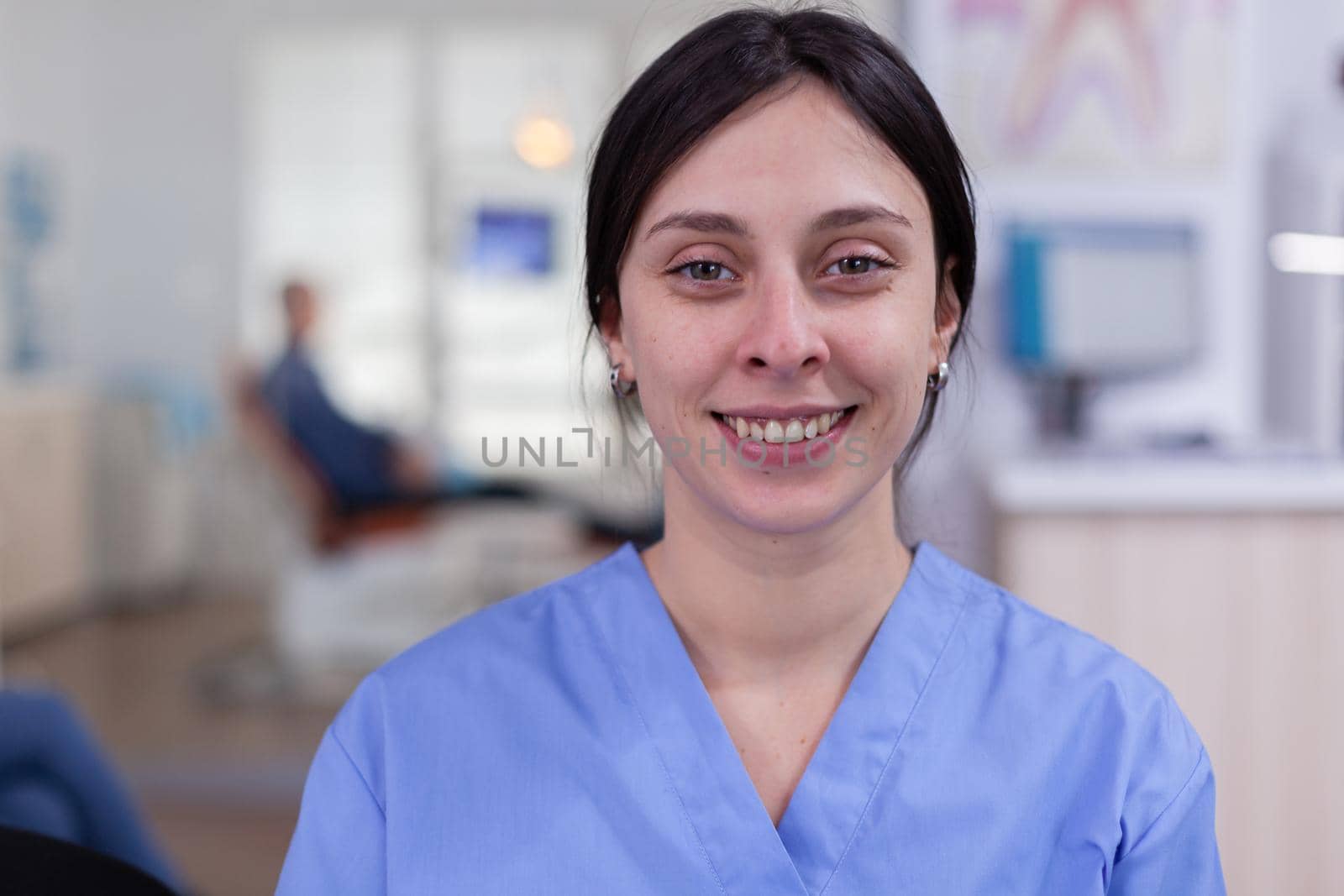 Dental assistant looking at camera in waiting area by DCStudio
