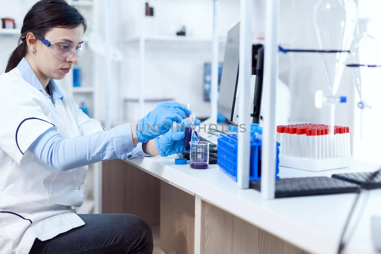 Woman scientist in healthcare industry taking sample from test tube using glass pipette. Chemistry scientist in sterile laboratory using modern technology to test microbiology liquid.