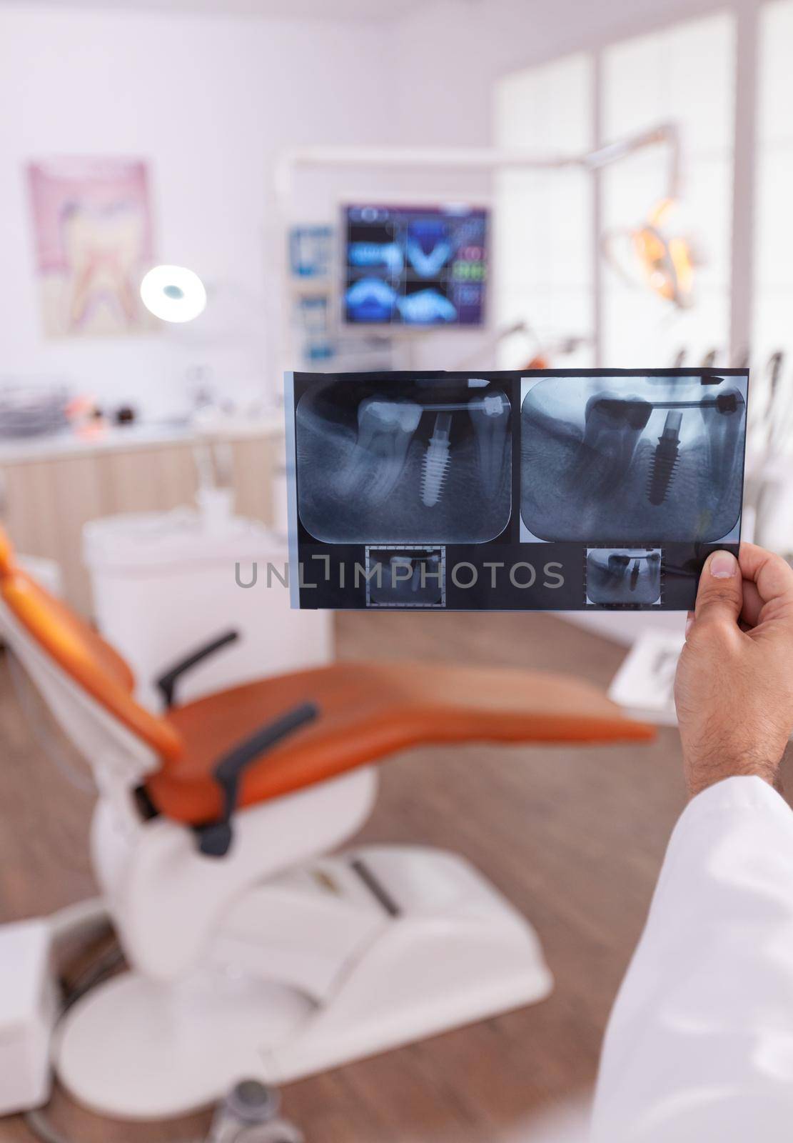 Orthodontist radiologist holding medical tooth radiography in hands analyzing dentistry surgery by DCStudio