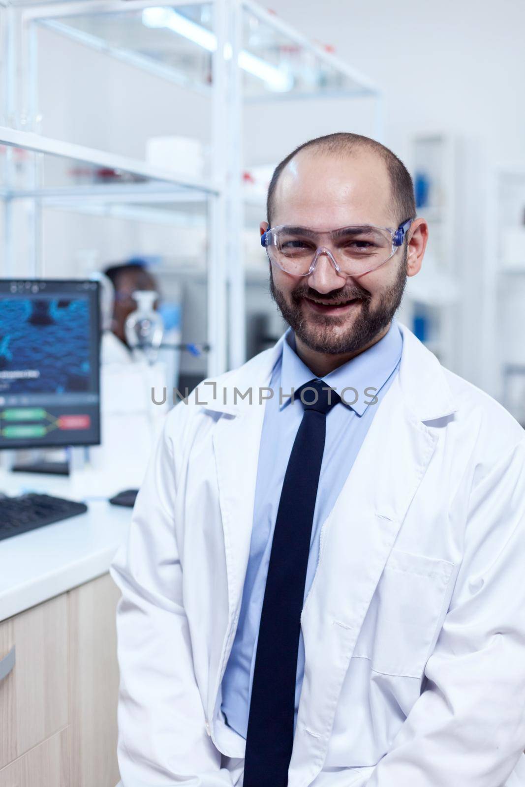 Young biochemistry scientist wearing protective glasses by DCStudio