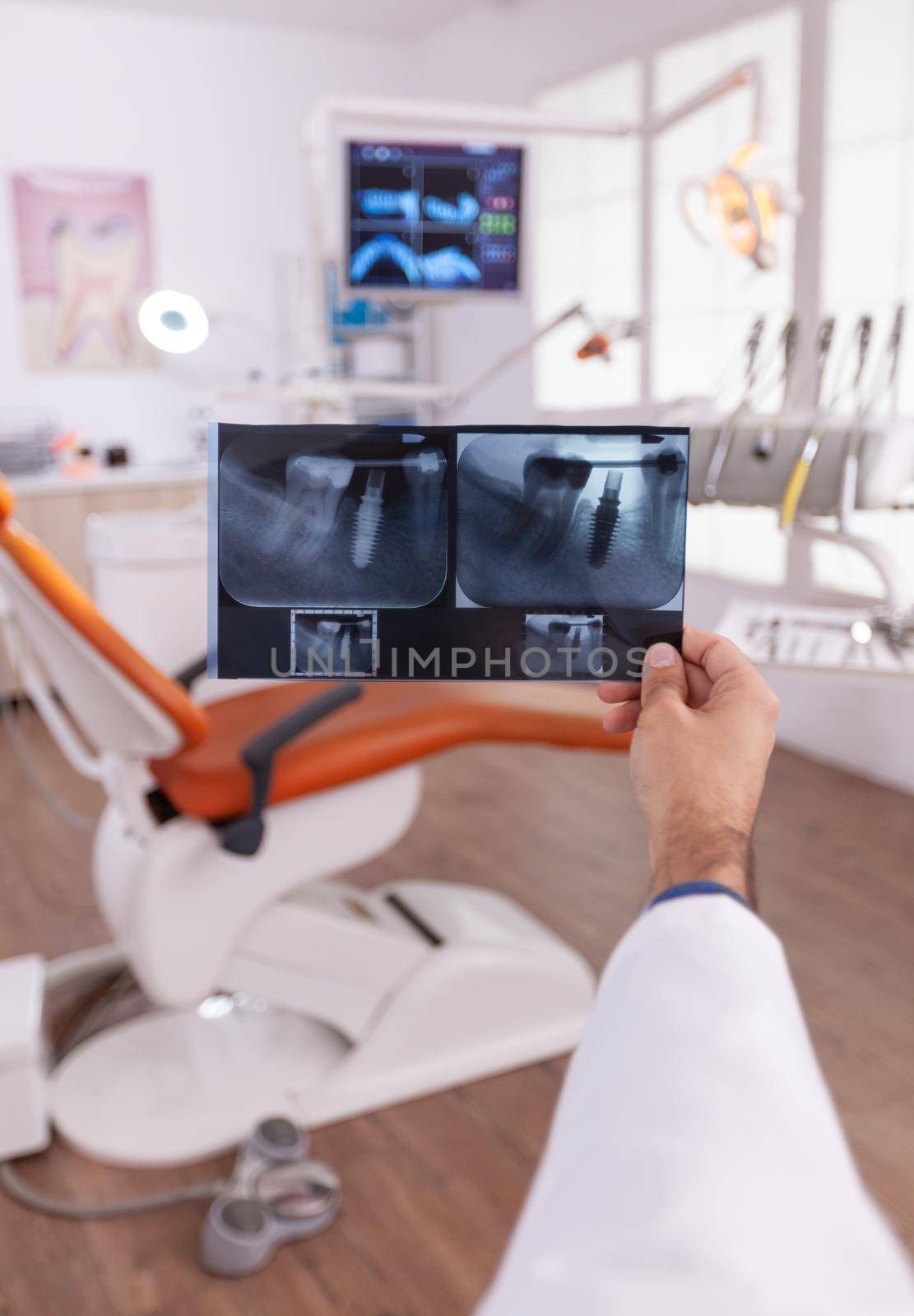 Radiologist looking at dental teeth jaw medical radiography working at teethcare treatment in stomatology orthodontic hospital diagnosis room. Orthodontist doctor examining surgery expertise