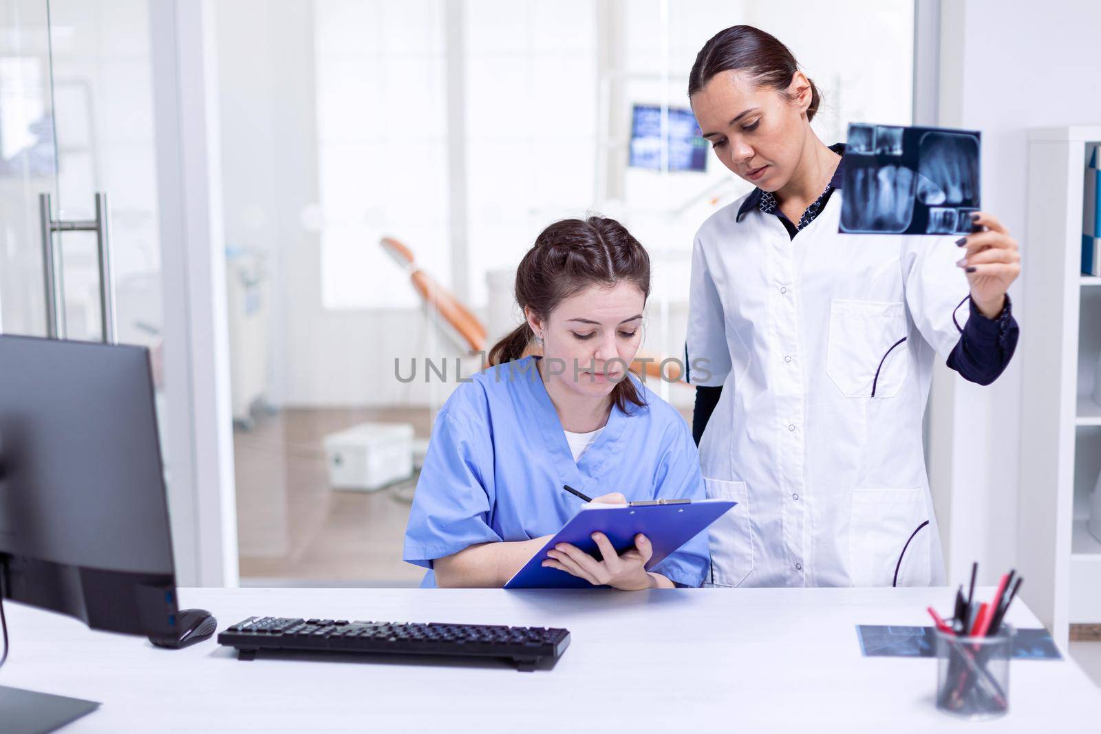 Dentist nurse taking notes about teeth hygine by DCStudio