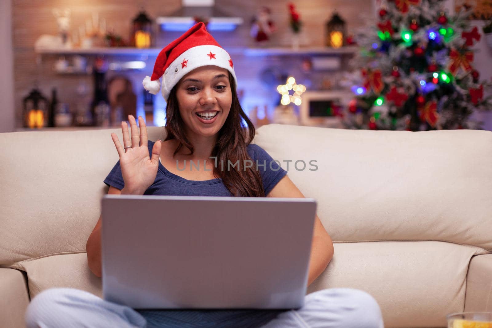 Smiling woman greeting remote friends enjoying christmastime together by DCStudio