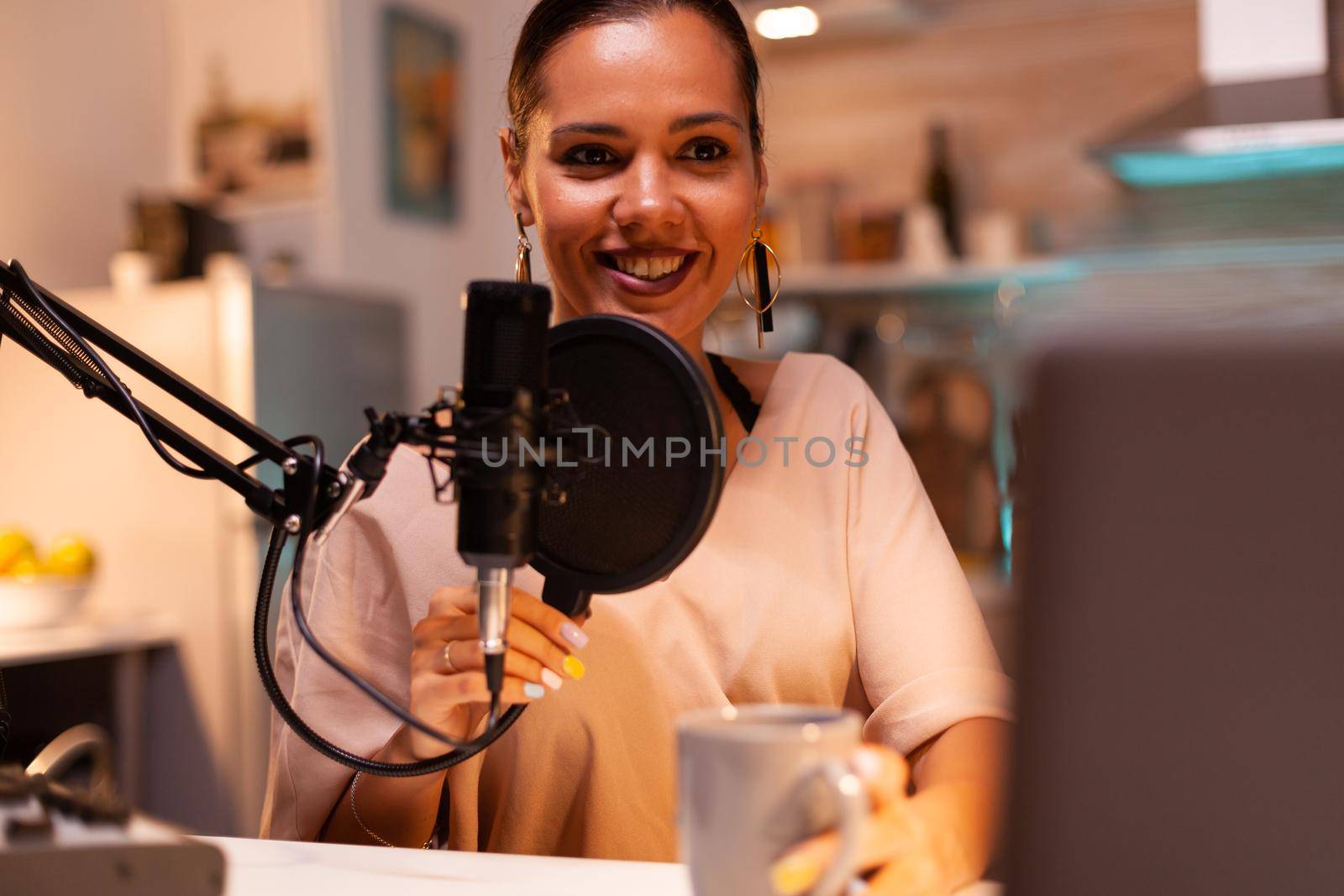 Woman recording sound in home studio for podcast. Creative online show presenter, video, sound production station in home , lifestyle night, web, internet, media equipment, laptop.