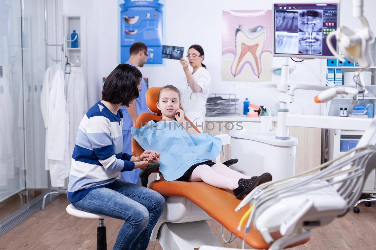 Kid holding hand on face because of pain after dentist treatment by DCStudio
