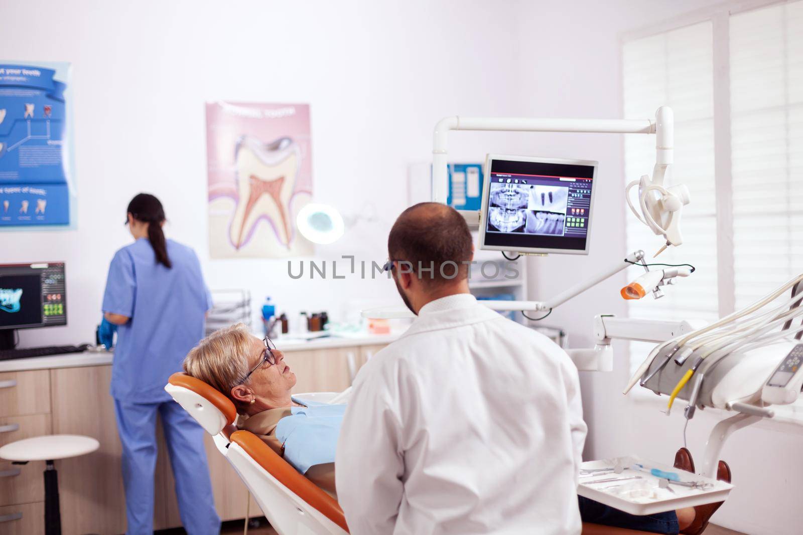 Senior woman discussing with dentist by DCStudio