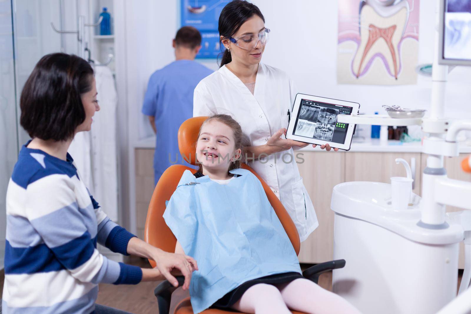 Dentist discussing diagnosis with child parent by DCStudio