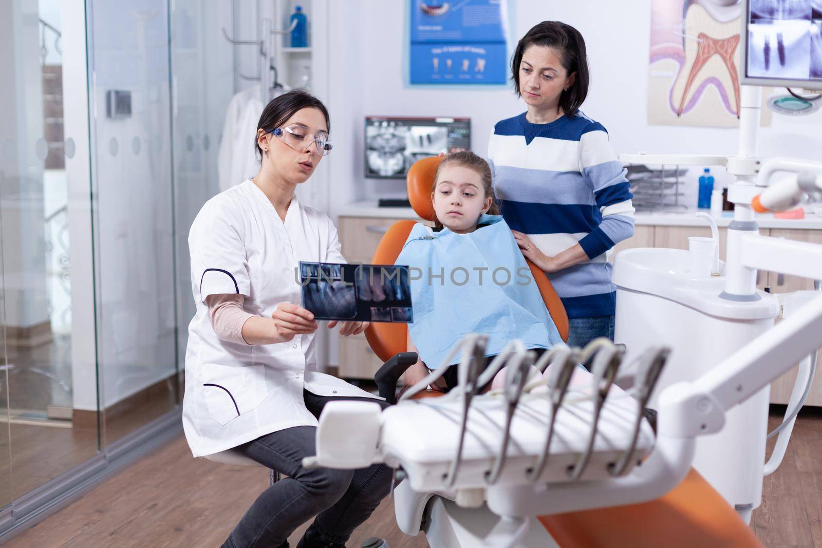 Cheerful little girl sitting in dental office by DCStudio
