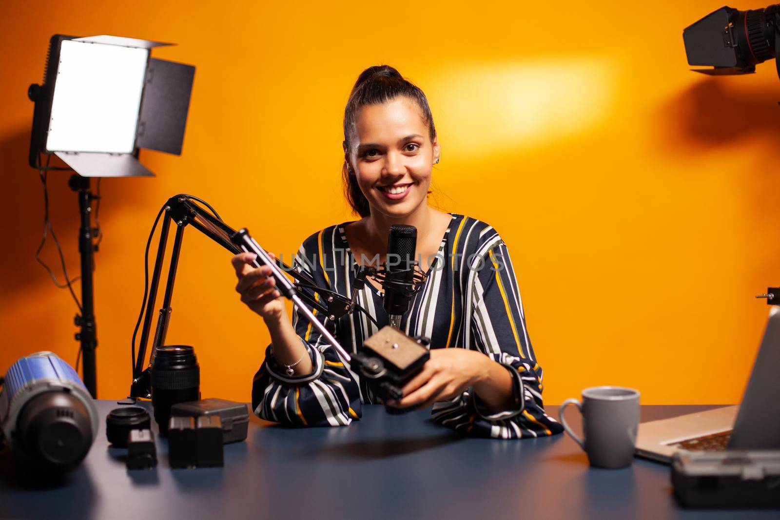 Holding videography equipment and recording podcast. Social media star making online internet content about video equipment for web subscribers and distribution, film