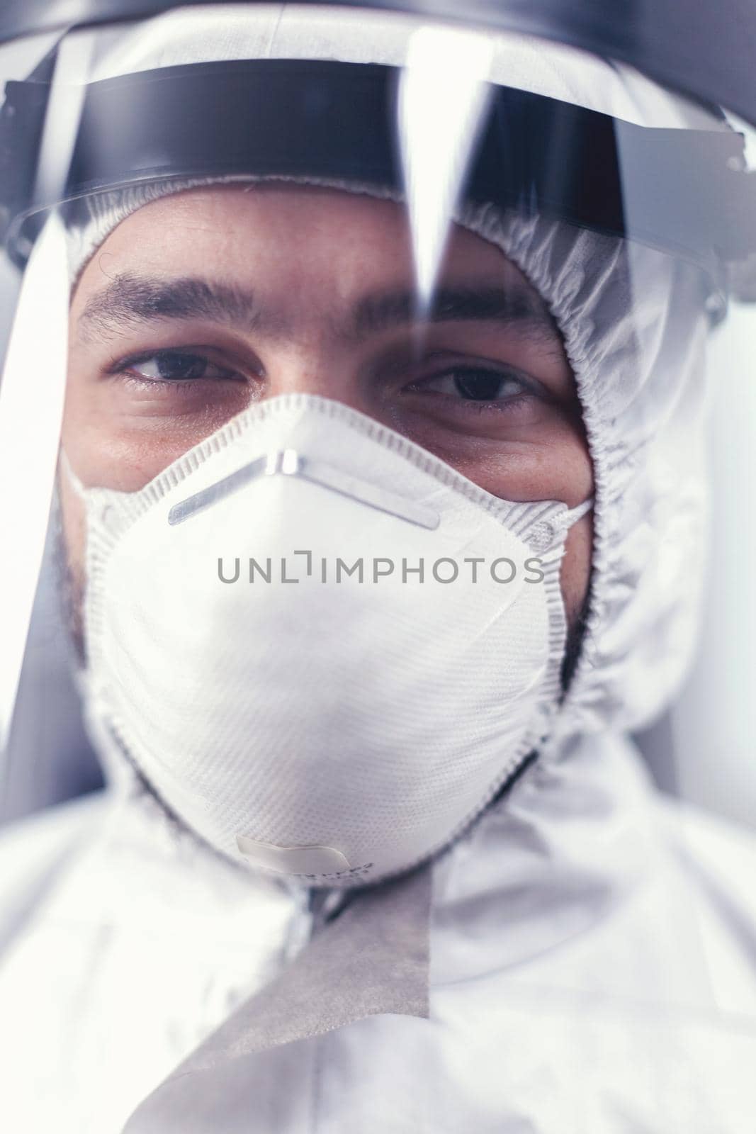 Close up of virus scientist wearing ppe equipment in microbiology laboratory during covid19. Overworked researcher dressed in protective suit against invection with coronavirus during global epidemic.