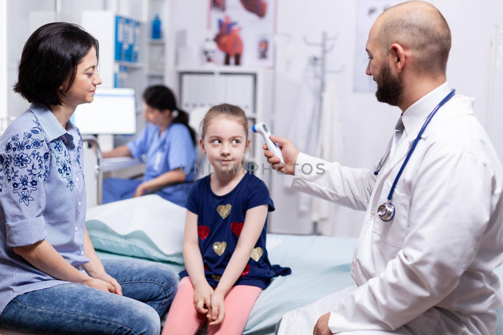 Doctor using digital thermometer to check body temperature of sick child during consultation. Healthcare physician specialist in medicine providing health care services treatment examination.