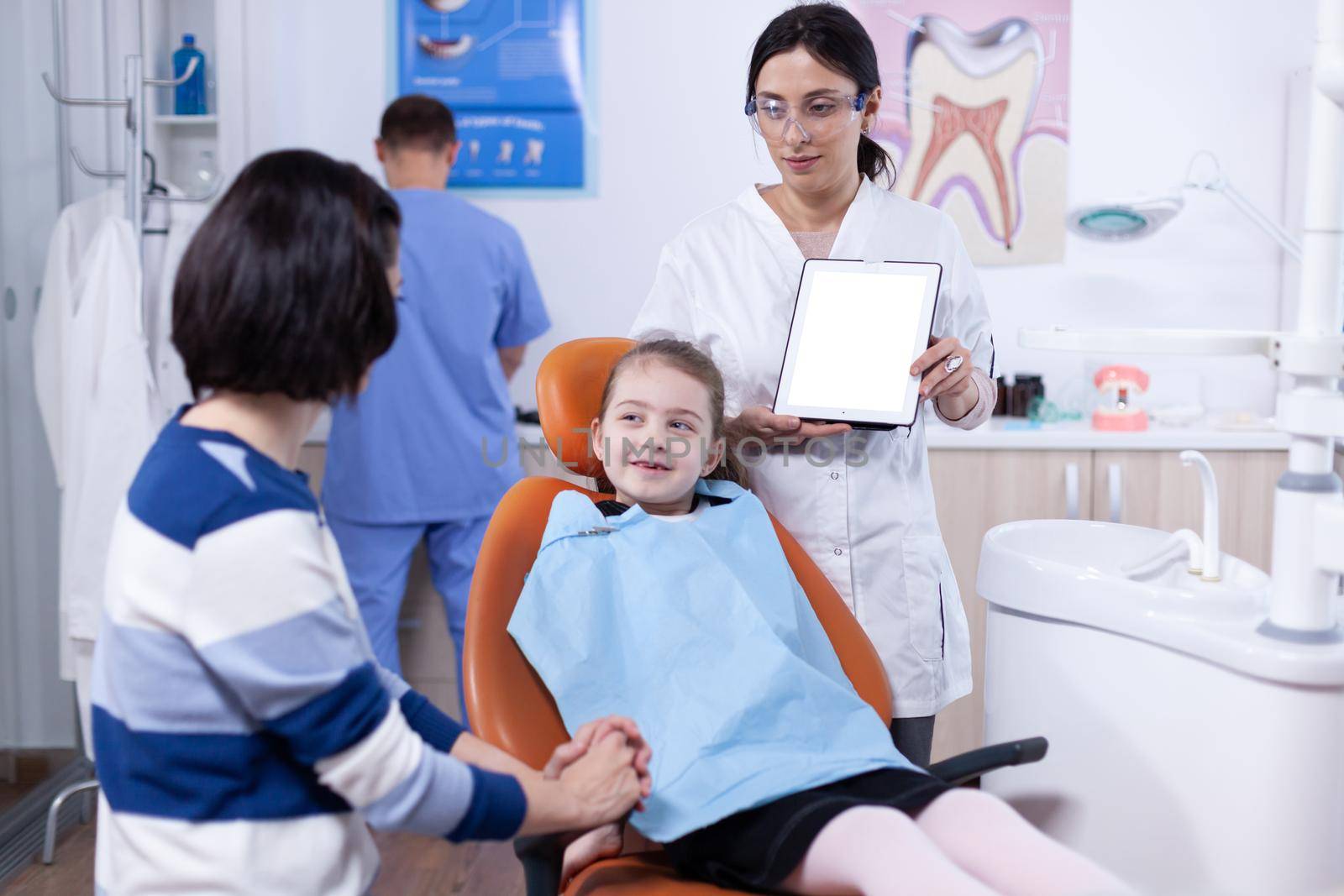 Little girl wearing dental bib in the course of dentistiry by DCStudio