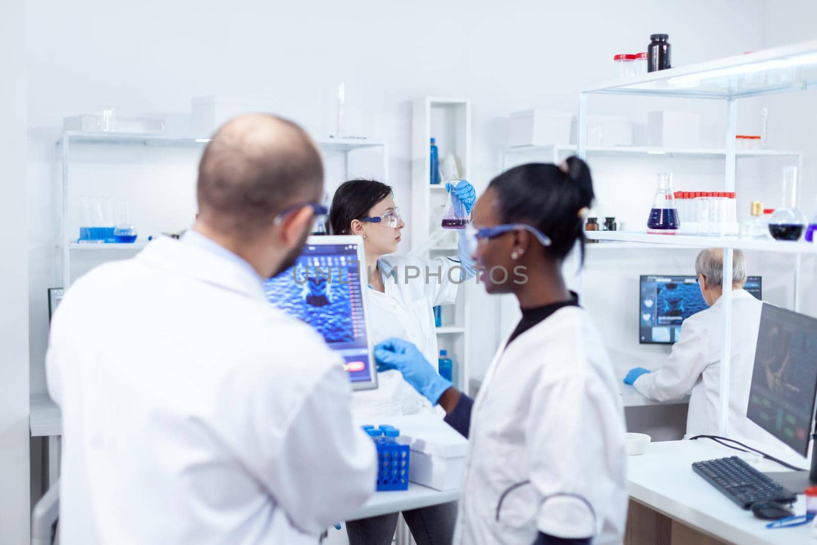 Scientist holding glass flask with blue genetic material by DCStudio