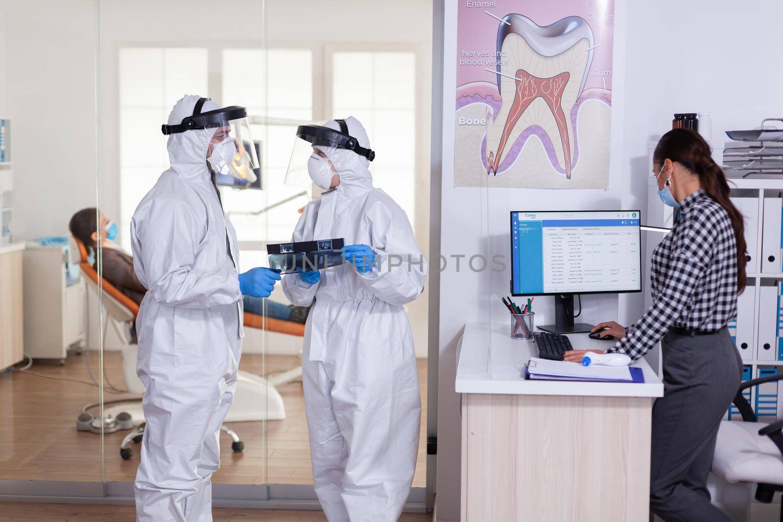 Dentist assistant discussing with doctor patient diagnosis by DCStudio