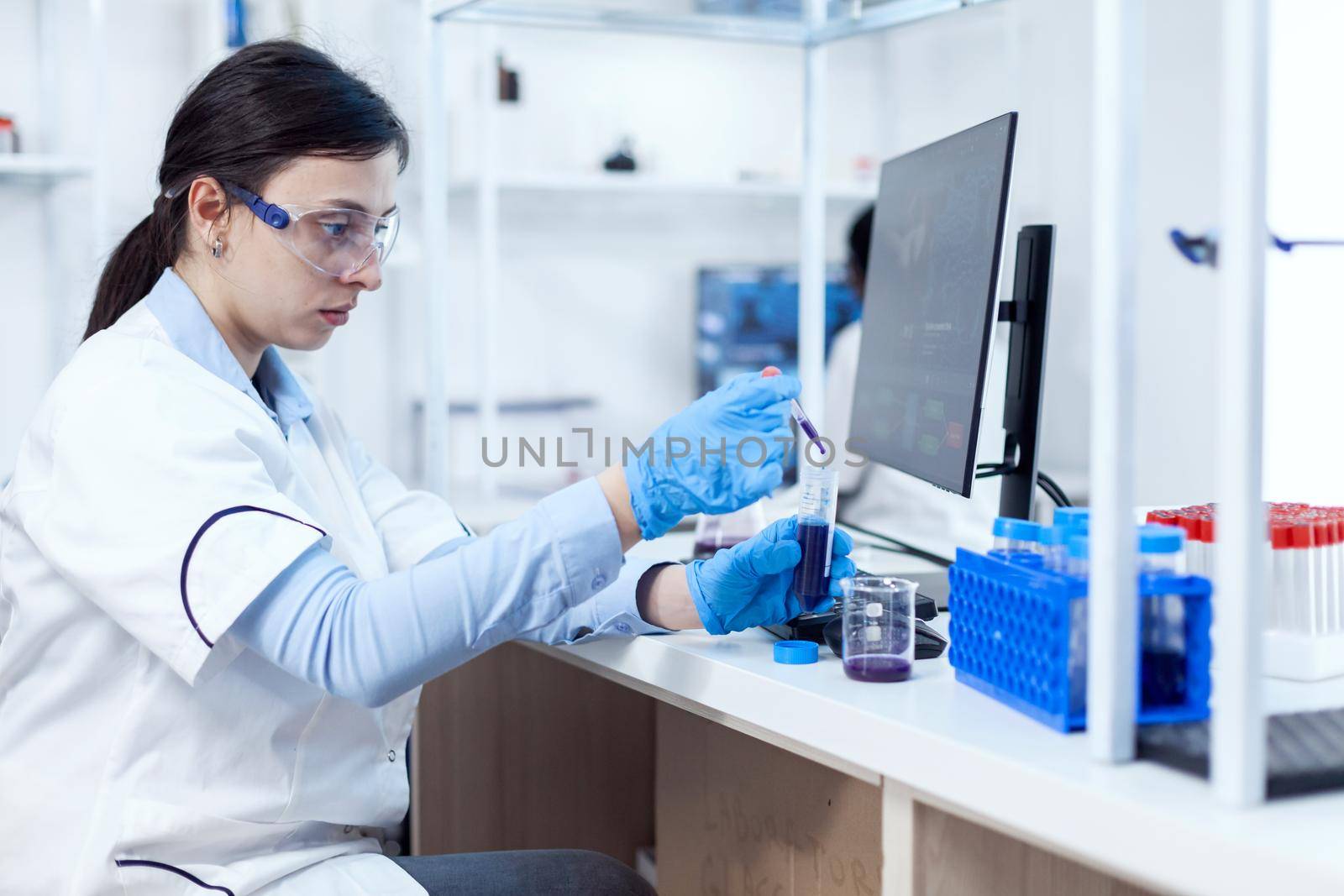 Young scientist loads pipette with sample for dna examination by DCStudio