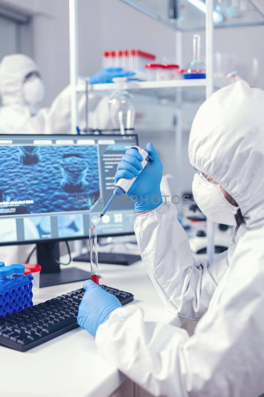 Scientist taking blood sample from test tube using micropipette. Doctor working with various bacteria and tissue, pharmaceutical research for antibiotics against covid19.