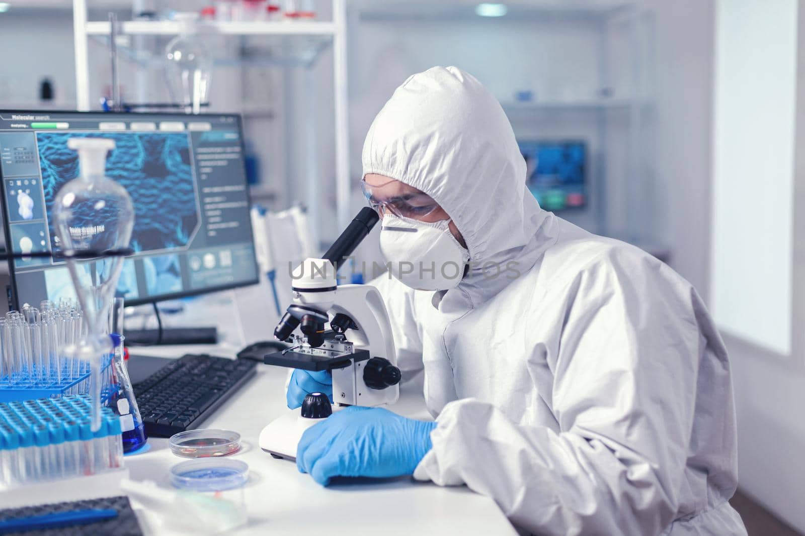 Healthcare specialist analyzing vaccine on microscope by DCStudio