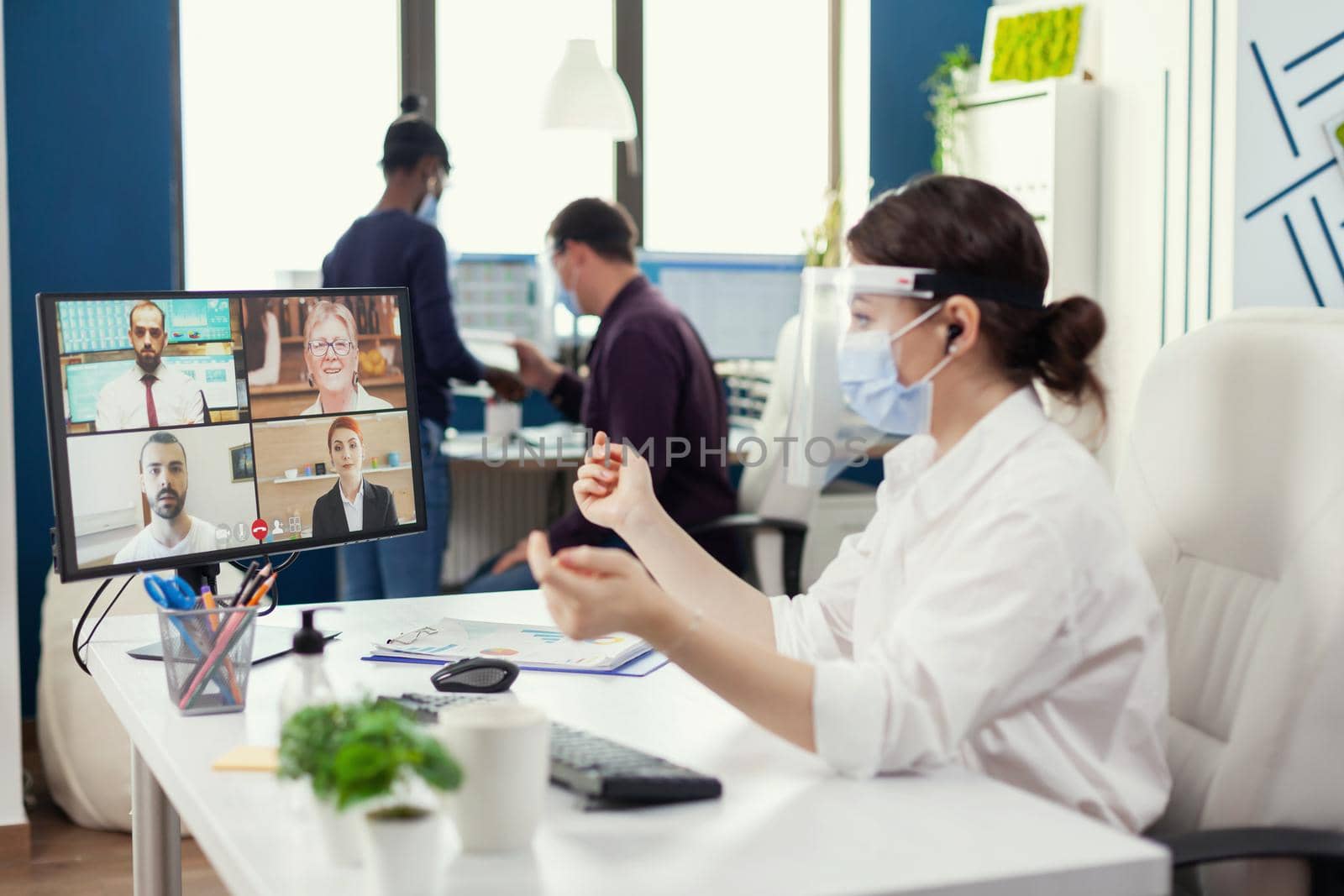 Businesswoman listening businesspeople during online conference by DCStudio