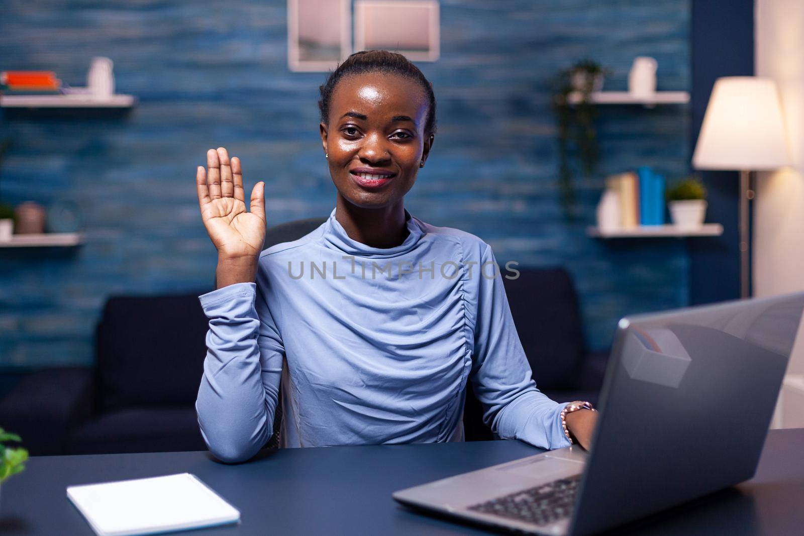 Dark skinned freelancer woman waving at camera in the course of video conference Black freelancer working with remotely team chatting virtual online conference.
