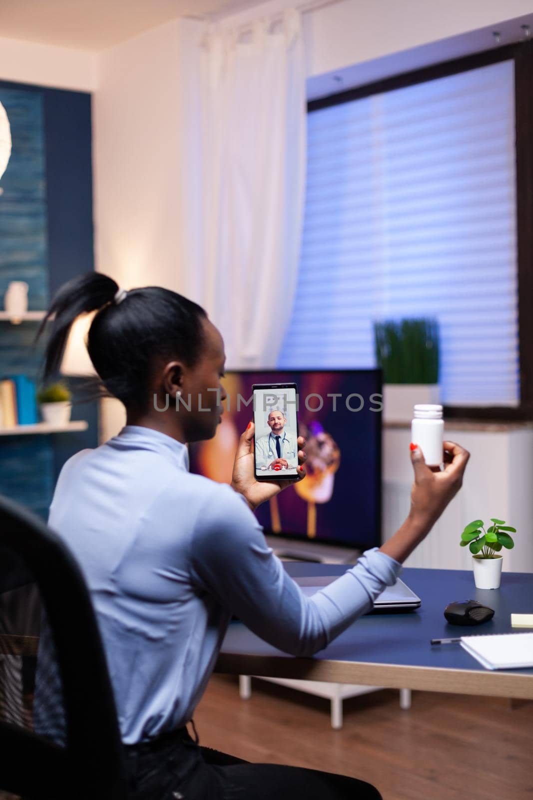 African woman listening health care physician talking during online consultation late at night. Black patient in a video call with medic discussing health problems of woman.
