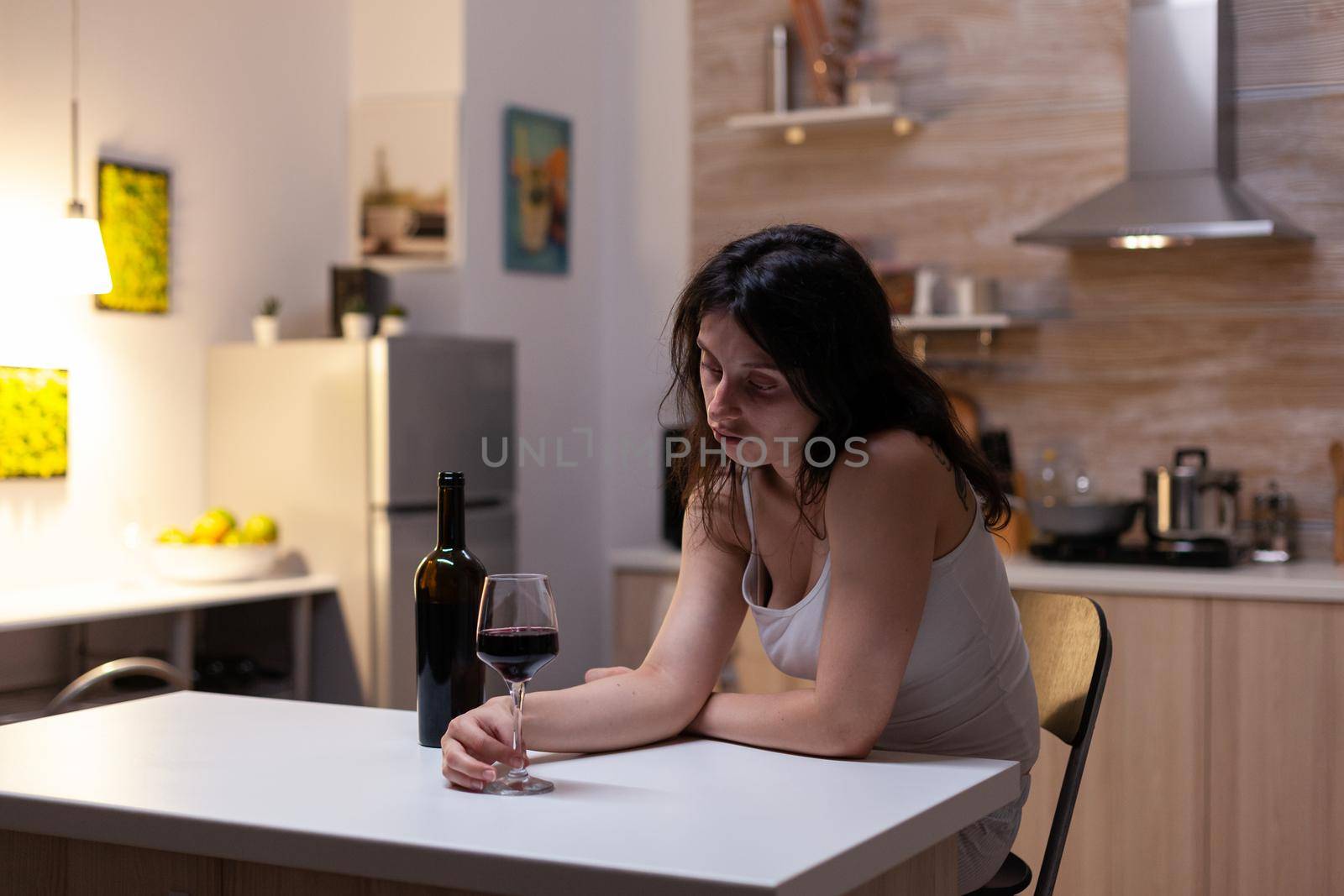 Depressive woman holding glass of wine feeling lonely by DCStudio