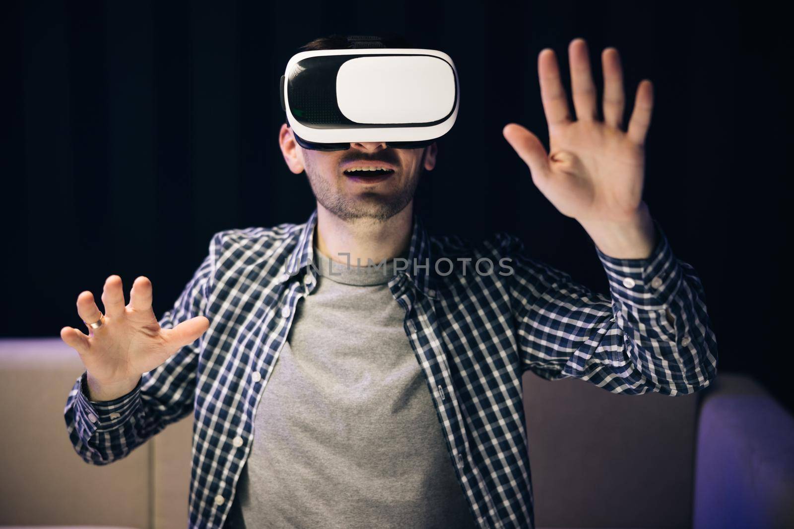 Man using modern 3D vr glasses indoors. Student playing using VR glasses. Handsome man wearing virtual reality headset. Augmented Reality.