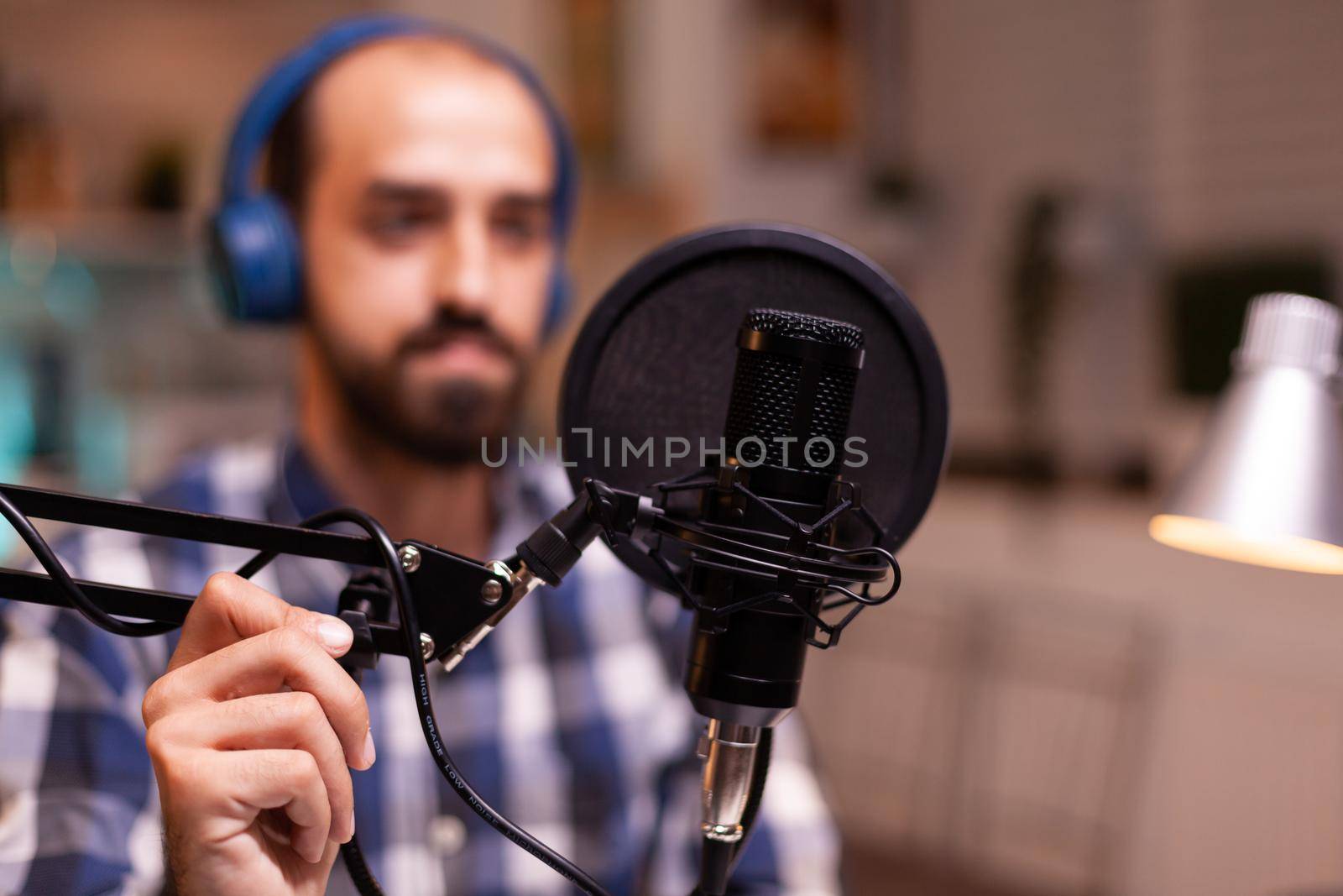 Blogger wearing headphones and talking about lifestyle during podcast Creative online show On-air production internet broadcast host streaming live content recording digital social media communication