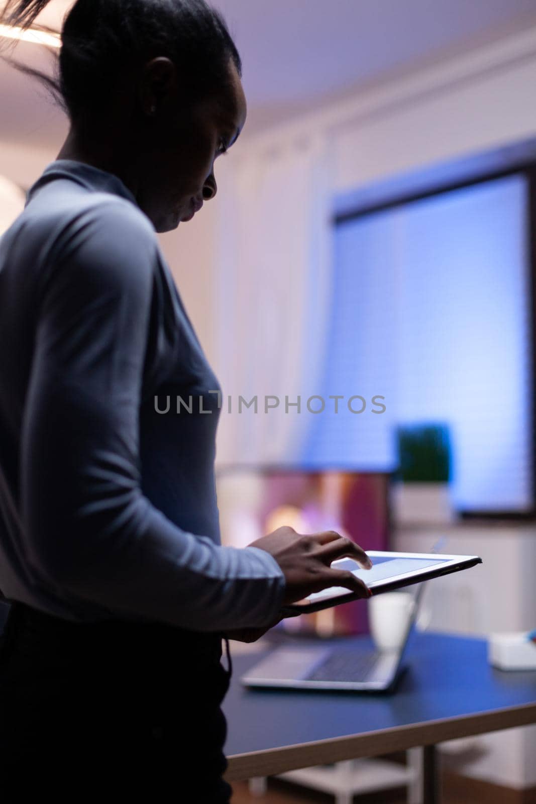 Dark skinned woman utilises tablet pc by DCStudio