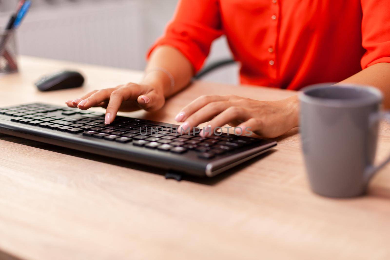 Unrecognizable businesswoman entrepreneur typing finance communcation in workplace. Busy successful employee sitting at table in workplace working on important financial project.
